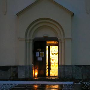 Beleuchteter Eingang der Pfarrkirche Dobl am Abend